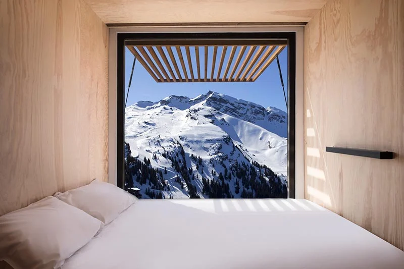 Minimal container hotel room with the bed placed beside the large window