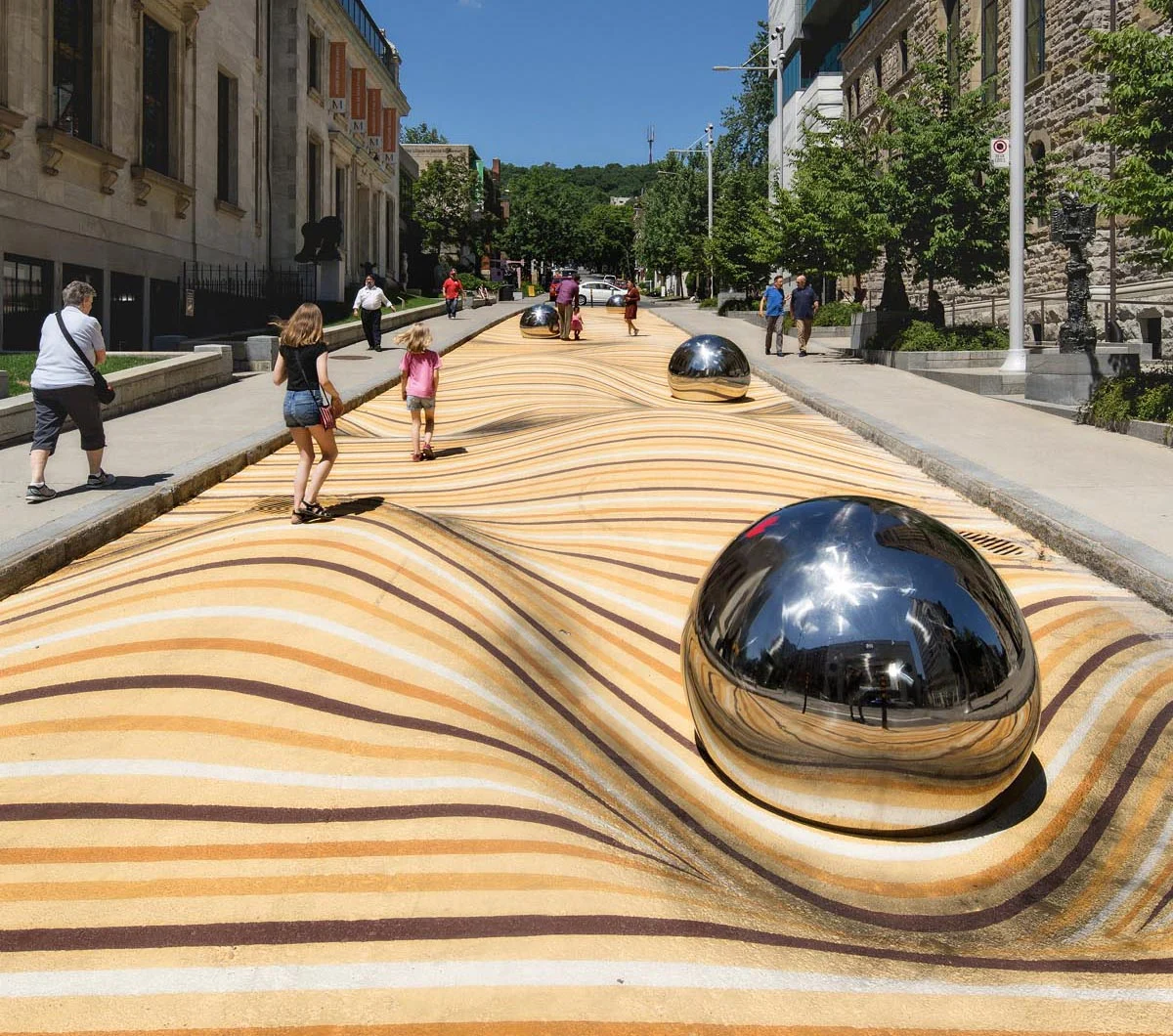 Moving Dunes street mural in Montreal with wave patterns and a mirrored sphere