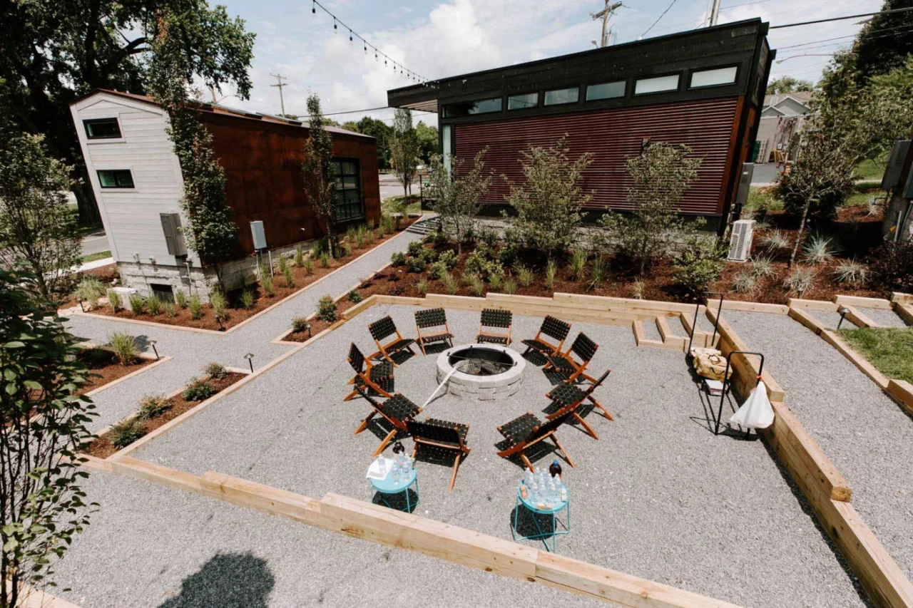 Central courtyard with a fire pit and chairs among the tiny homes at Ironwood Grove