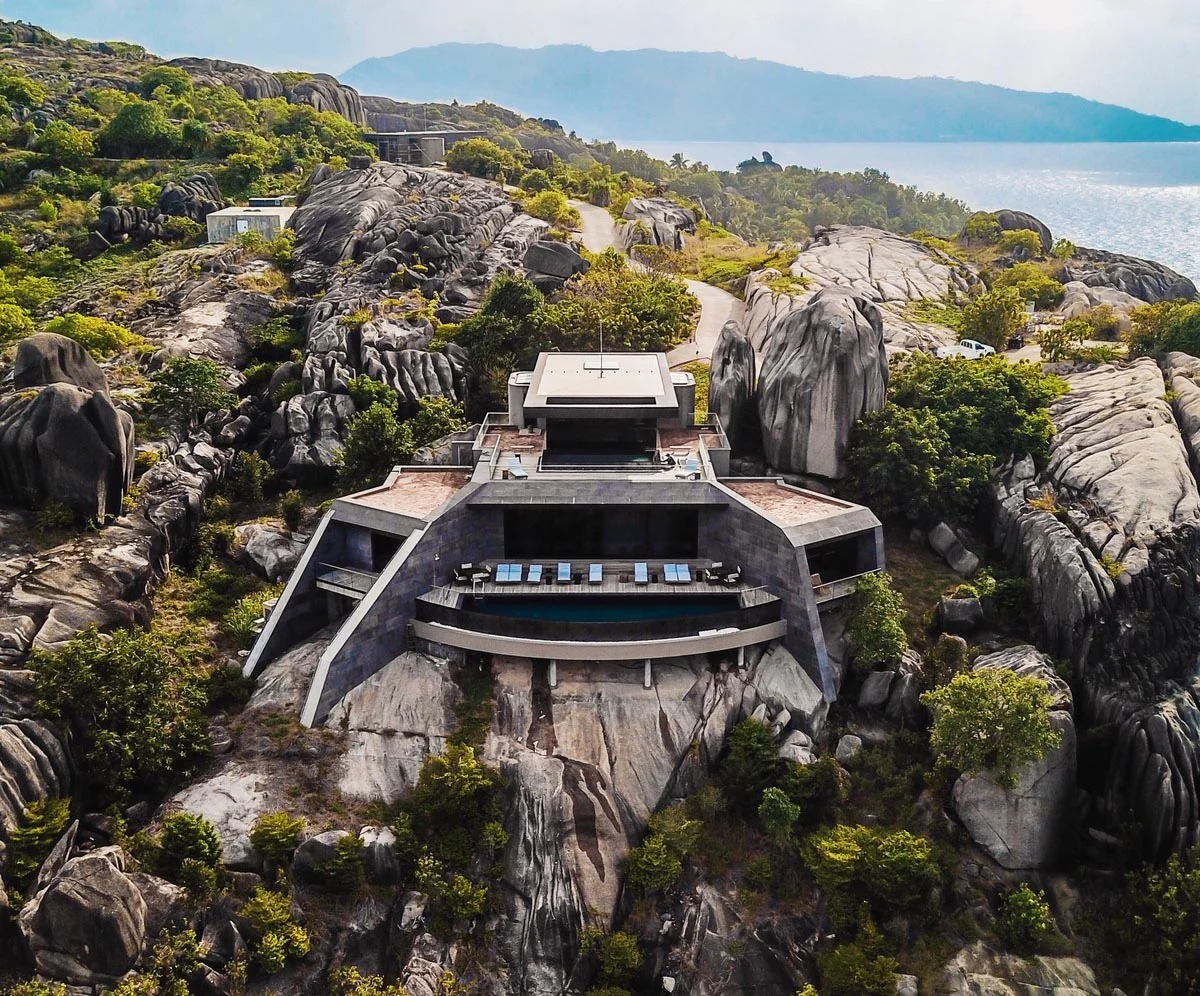 Black granite-clad houses by Studio RHE rising from weathered granite cliffs on Félicité in the Seychelles