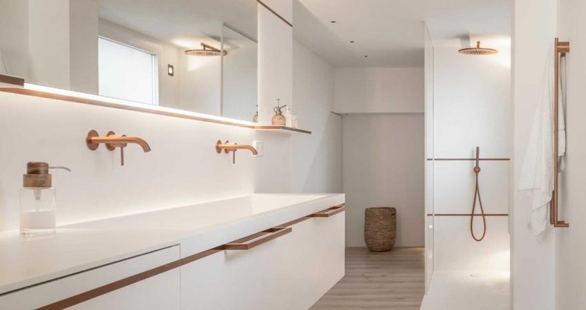 copper-tones-are-balanced-by-white-corian-in-this-minimalist-bathroom