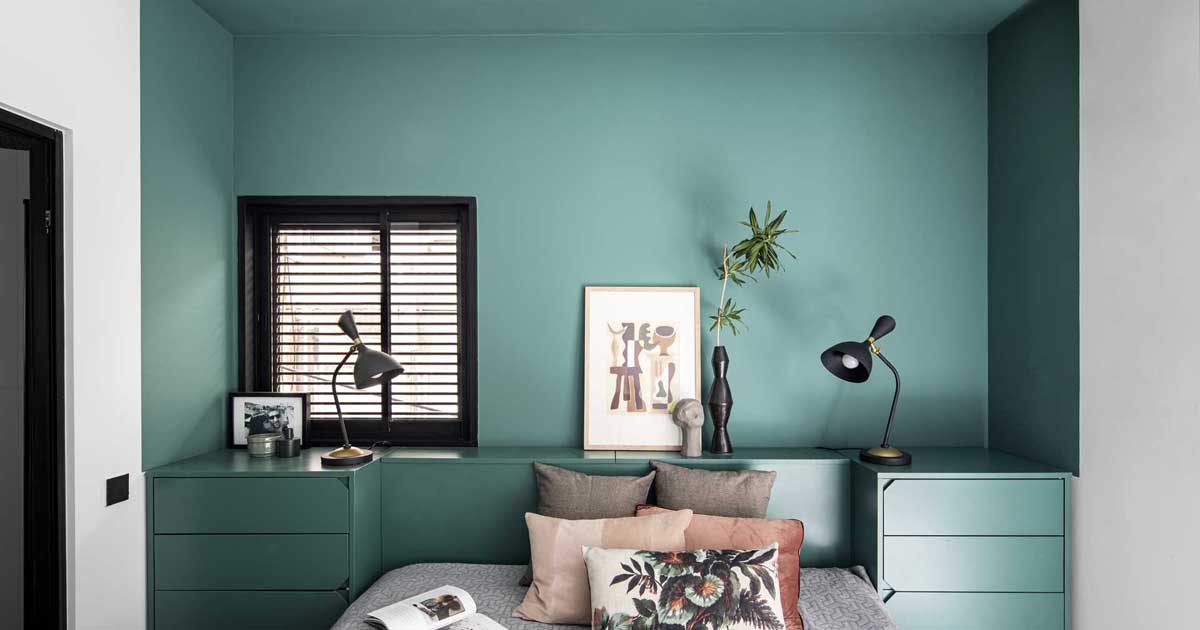 a-green-accent-wall-frames-the-bed-and-headboard-in-this-bedroom
