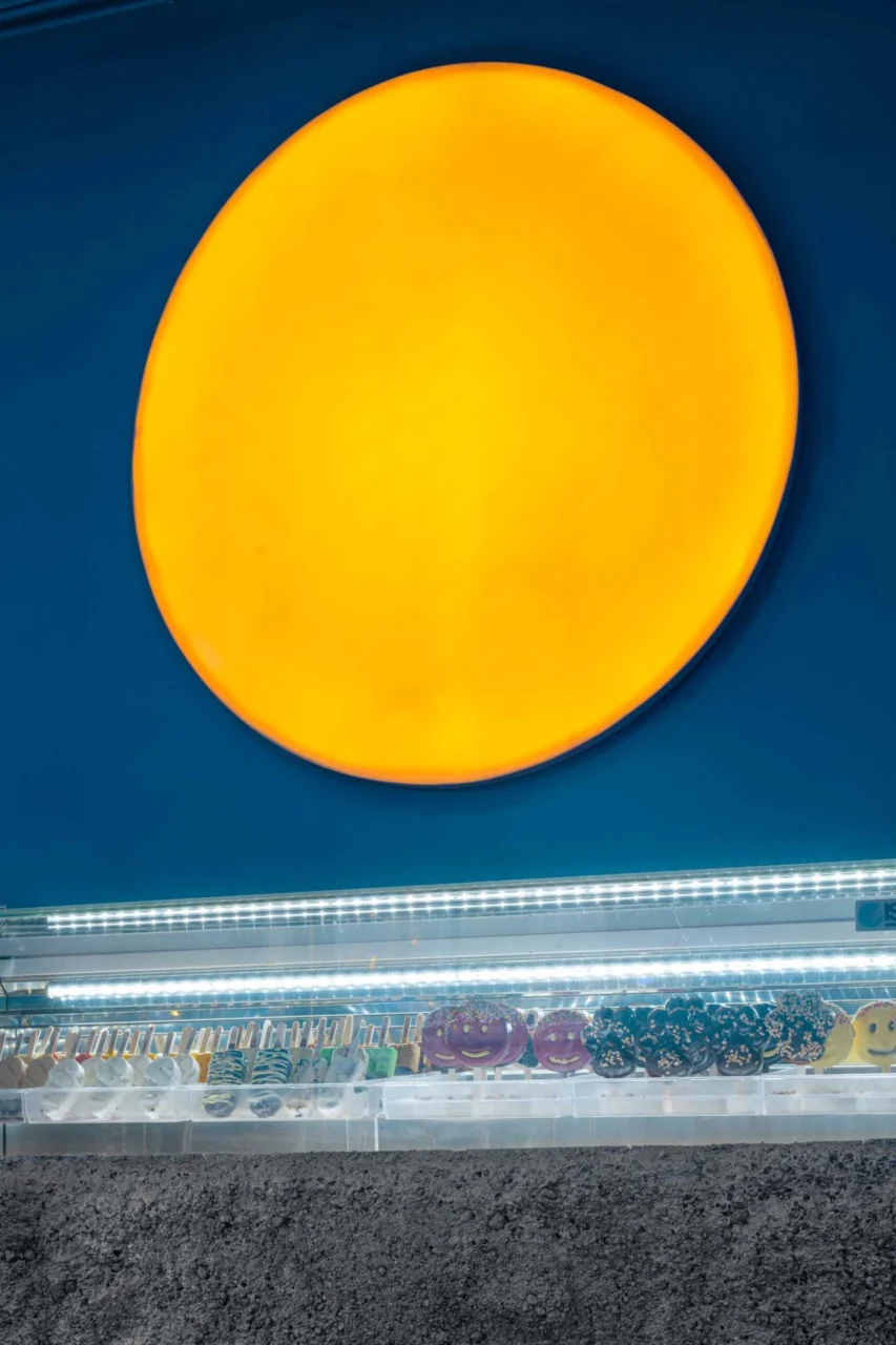 Large round light with an orange glow on an all-blue wall