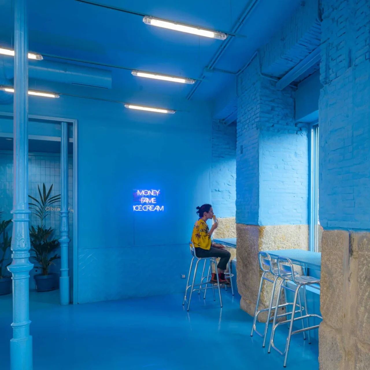 Counter seating by the windows against painted blue brick
