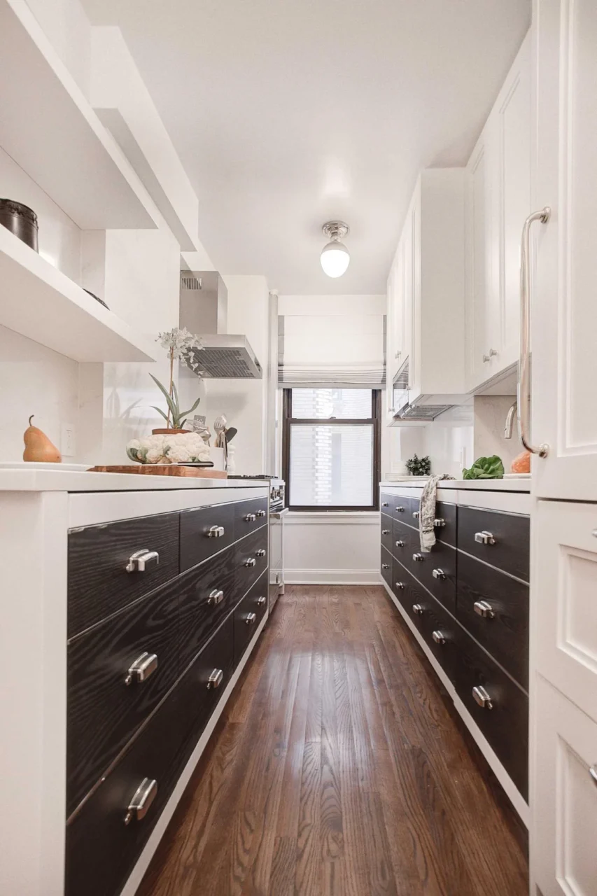 Black lower cabinets, white upper cabinets and warm wood flooring