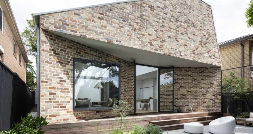 the-angled-brick-walls-of-this-home-allow-for-a-window-seat-in-the-living-room