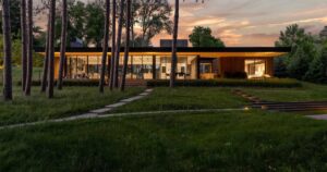a-deep-overhanging-roof-covers-the-glass-walls-of-this-lake-house