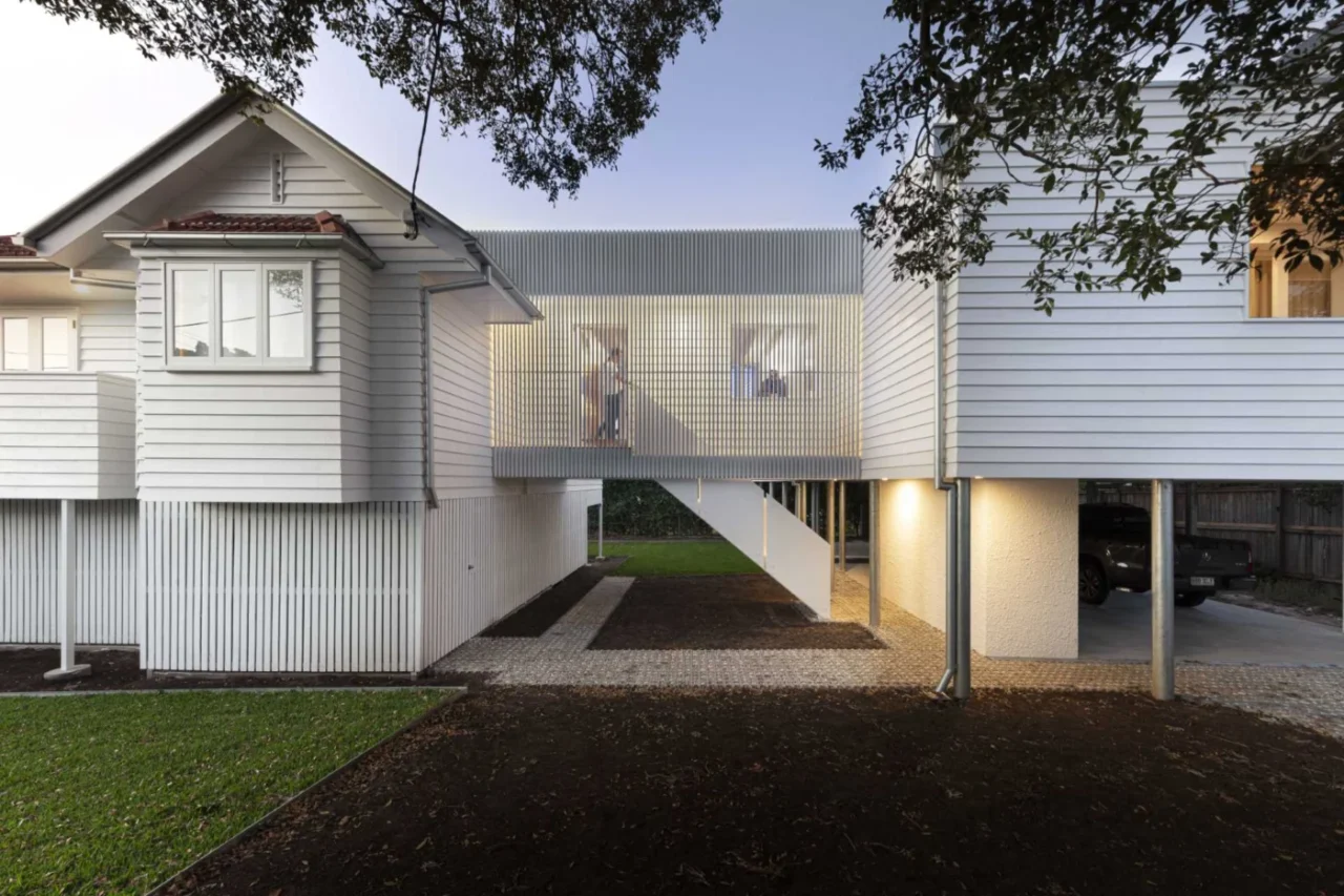 Elevated walkway with windows and stairs connecting the original Queensland house to the new extension