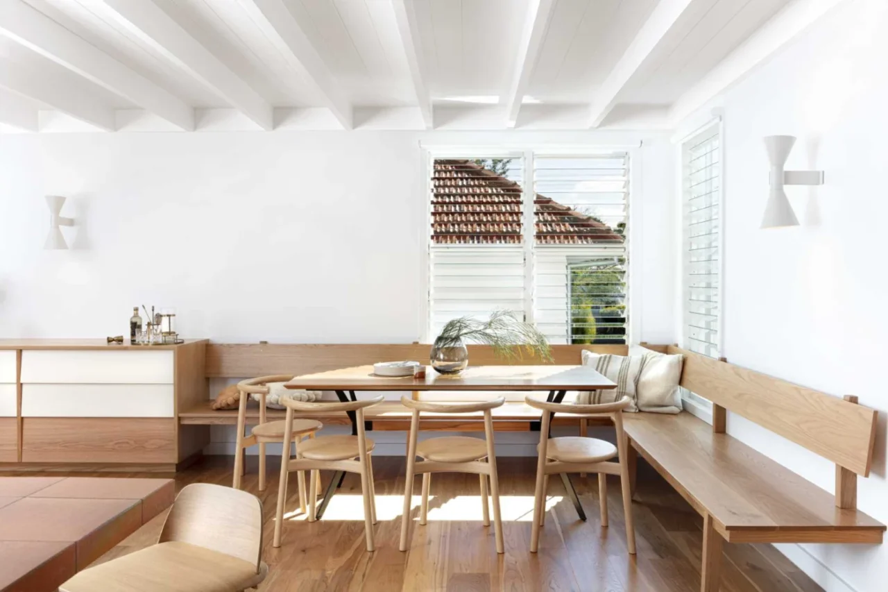 Open-plan dining room with a wood banquette wrapping the corner