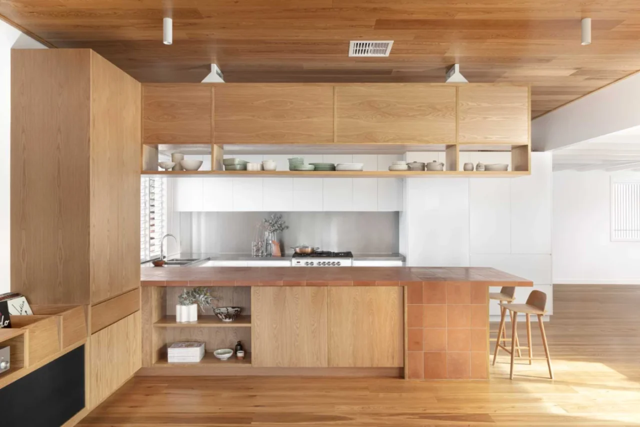 Kitchen with a peninsula clad in terracotta tiles