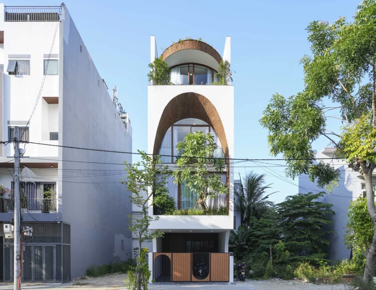 Narrow family house in Vietnam by 85 Design with a large arch on its facade