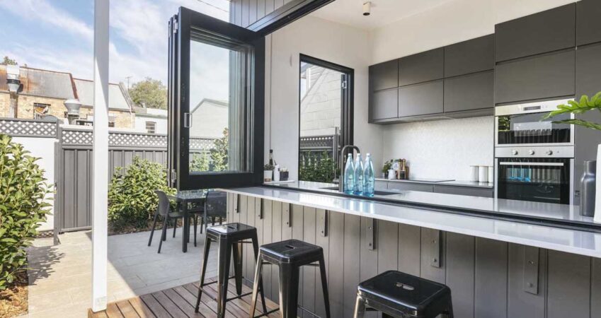 a-wall-of-bi-fold-windows-open-this-kitchen-to-the-outdoors