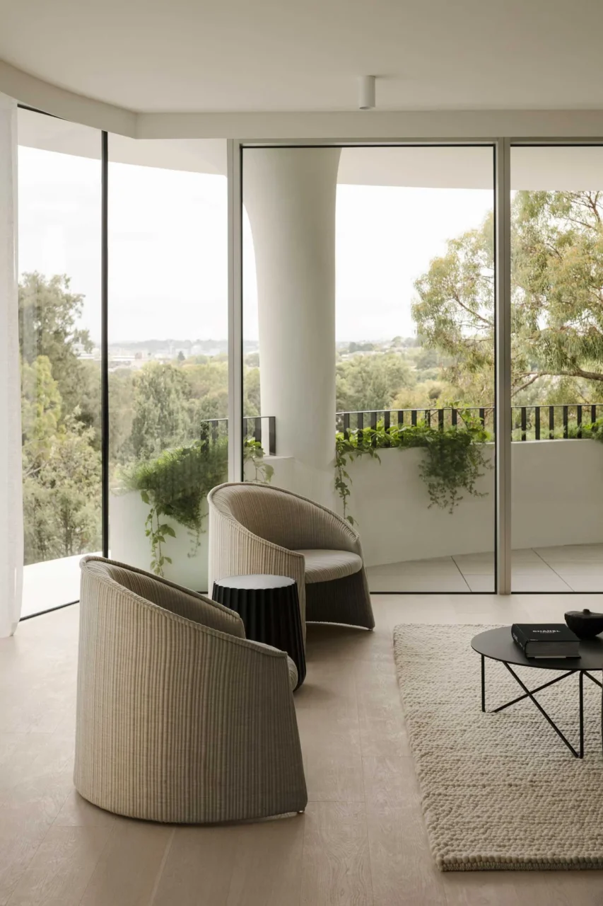 Living room looking out through full-height glazing to the curved terrace