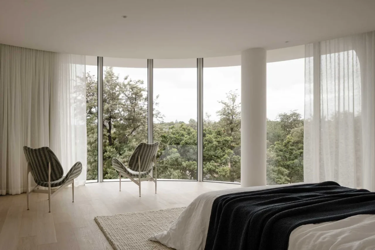 Bedroom with floor-to-ceiling windows and soft, light curtains