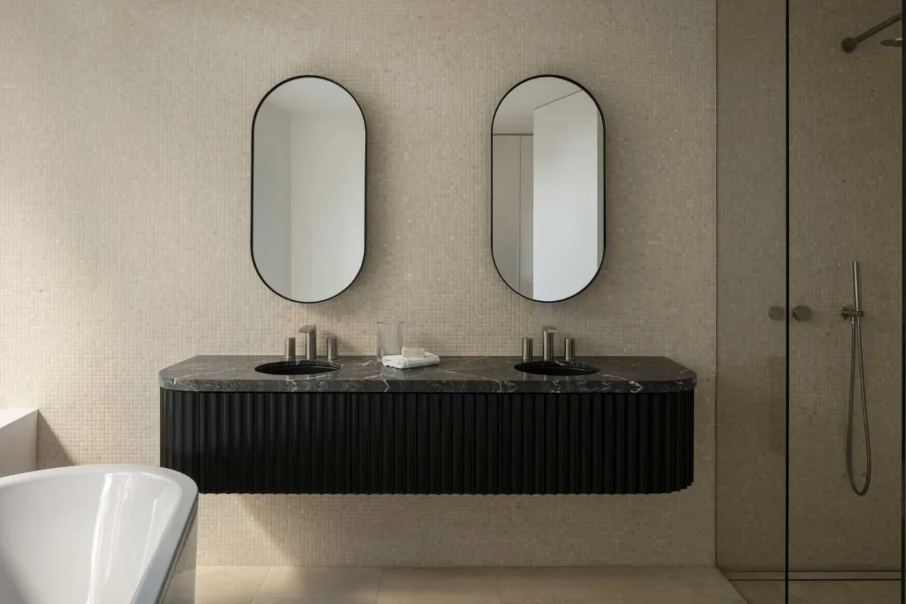 Bathroom lined in travertine mosaic tile with a floating vanity of stained timber and stone
