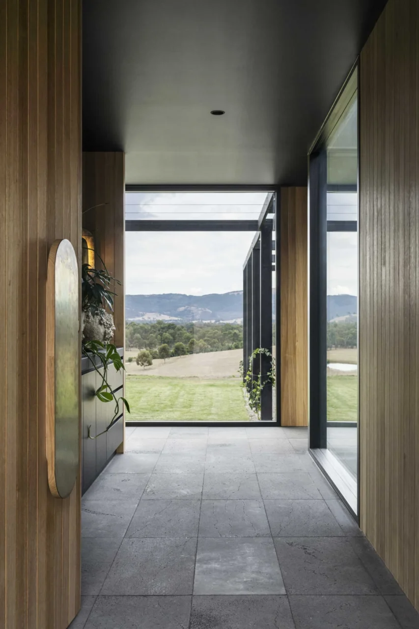 Hallway with bluestone tiling, charcoal cabinetry and ceilings, and timber cladding