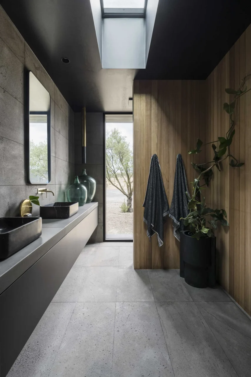 Bathroom with a floating black vanity, black ceiling and skylight