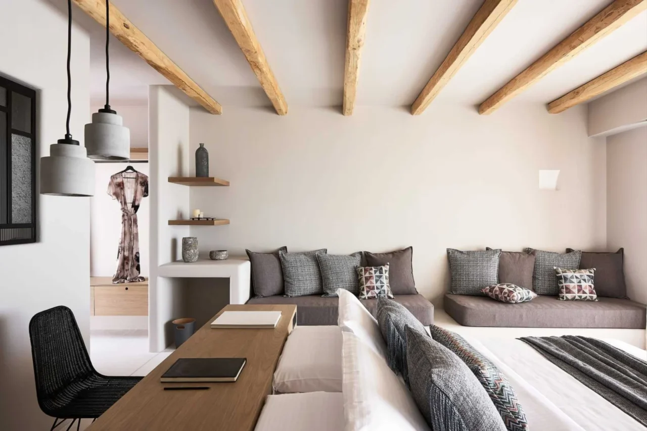 Bed placed centrally in the room with a built-in sofa along the wall, Cave Suites Milos