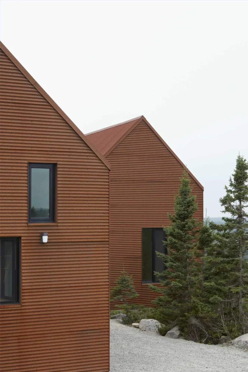 Black-framed doors and windows contrasting with rusty steel cladding