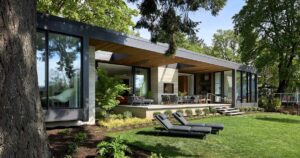 a-partially-covered-outdoor-fireplace-creates-a-space-to-enjoy-the-river-views-at-this-home