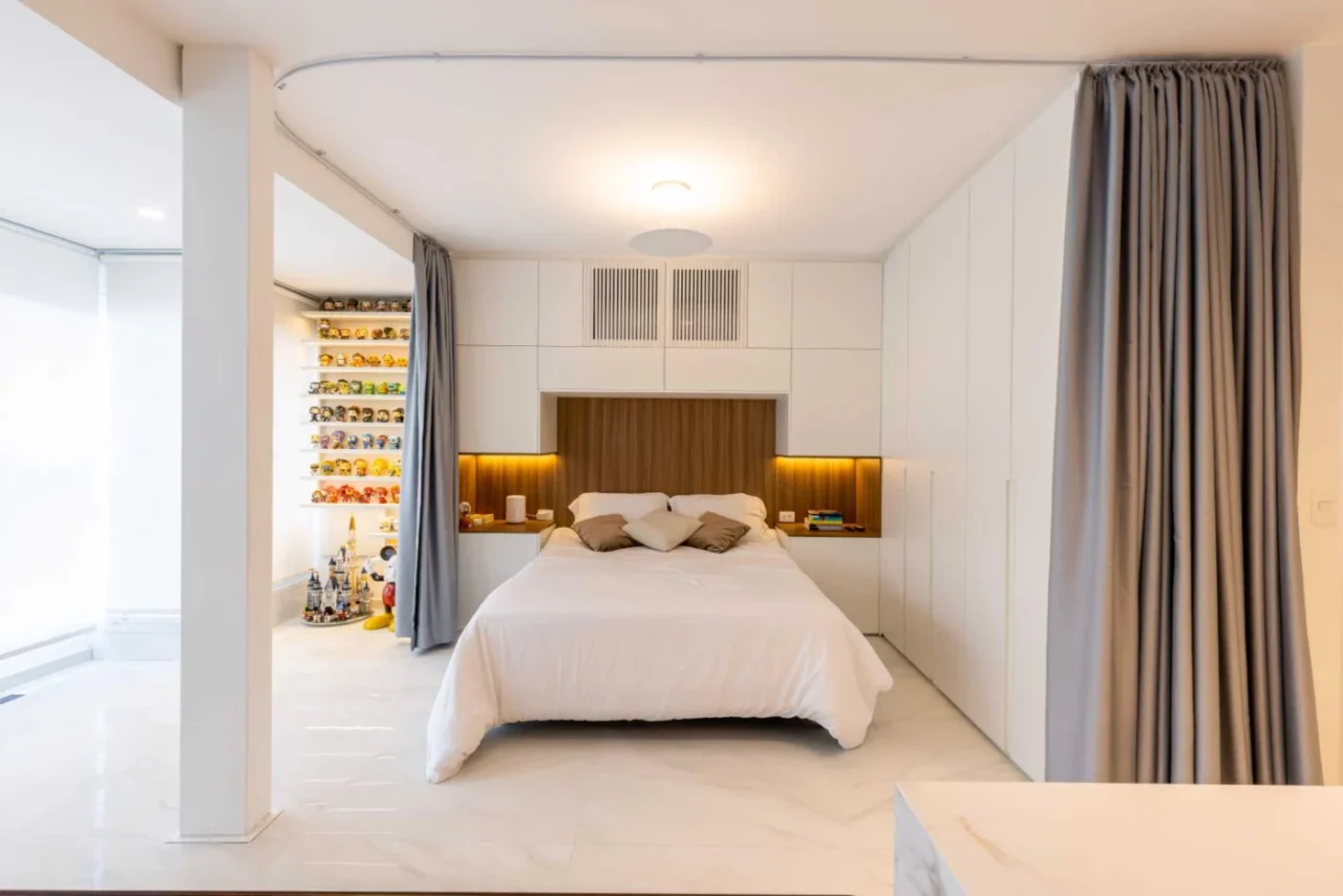 Open-plan bedroom with curtains as walls in a small Sao Paulo apartment by Bruno Kim Arquitetura