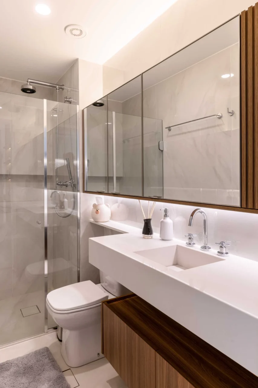 Bathroom with a low wood cabinet, vanity with built-in sink and walk-in shower