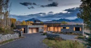 clad-in-stone,-wood,-steel,-and-glass,-this-house-nestles-quietly-within-the-natural-surroundings
