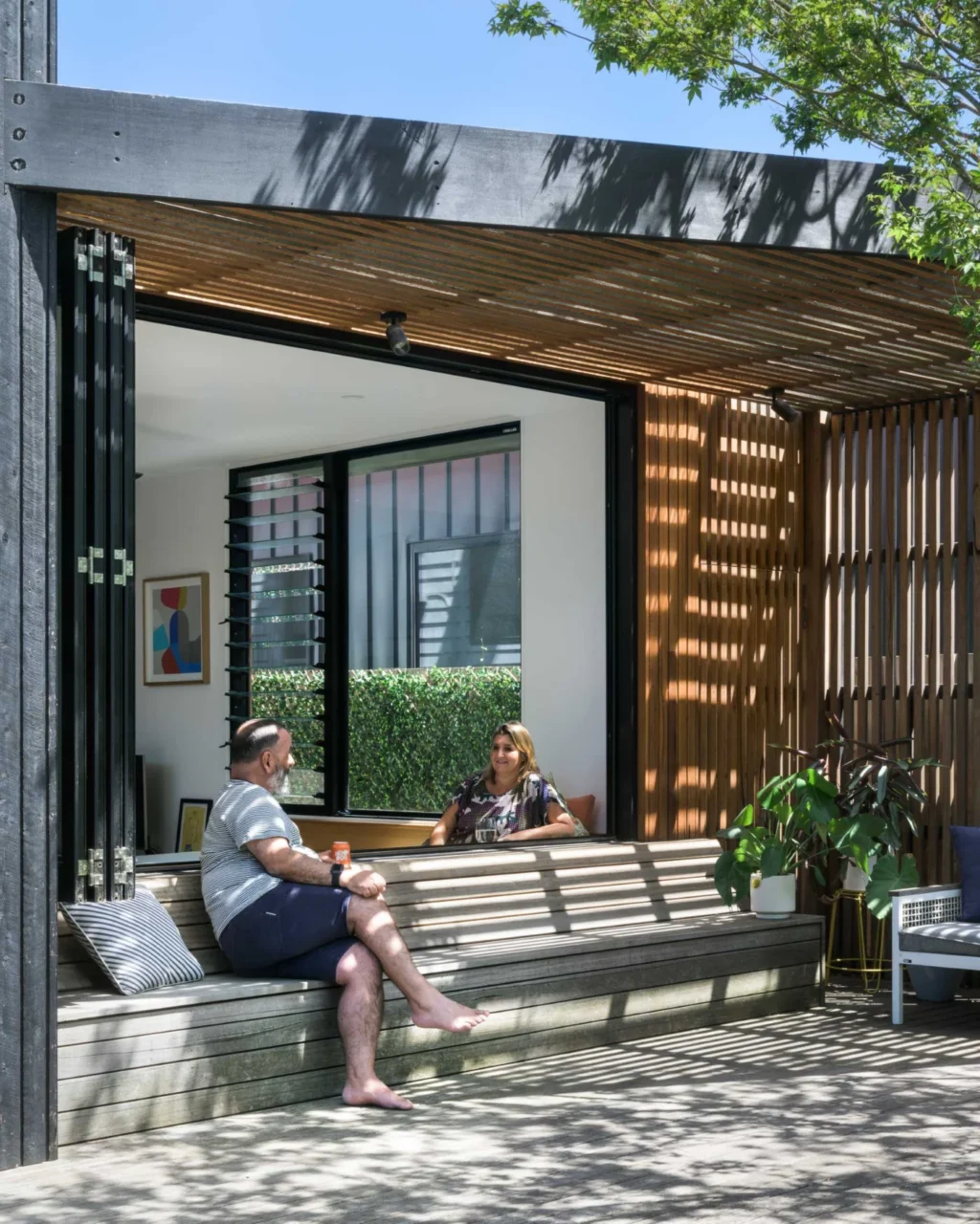 Shaded corner of the deck with built-in bench seating under timber battens