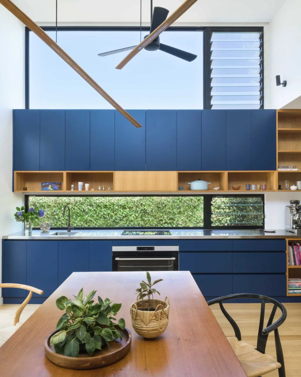 Country-style kitchen with a long table instead of an island and blue wall cabinets