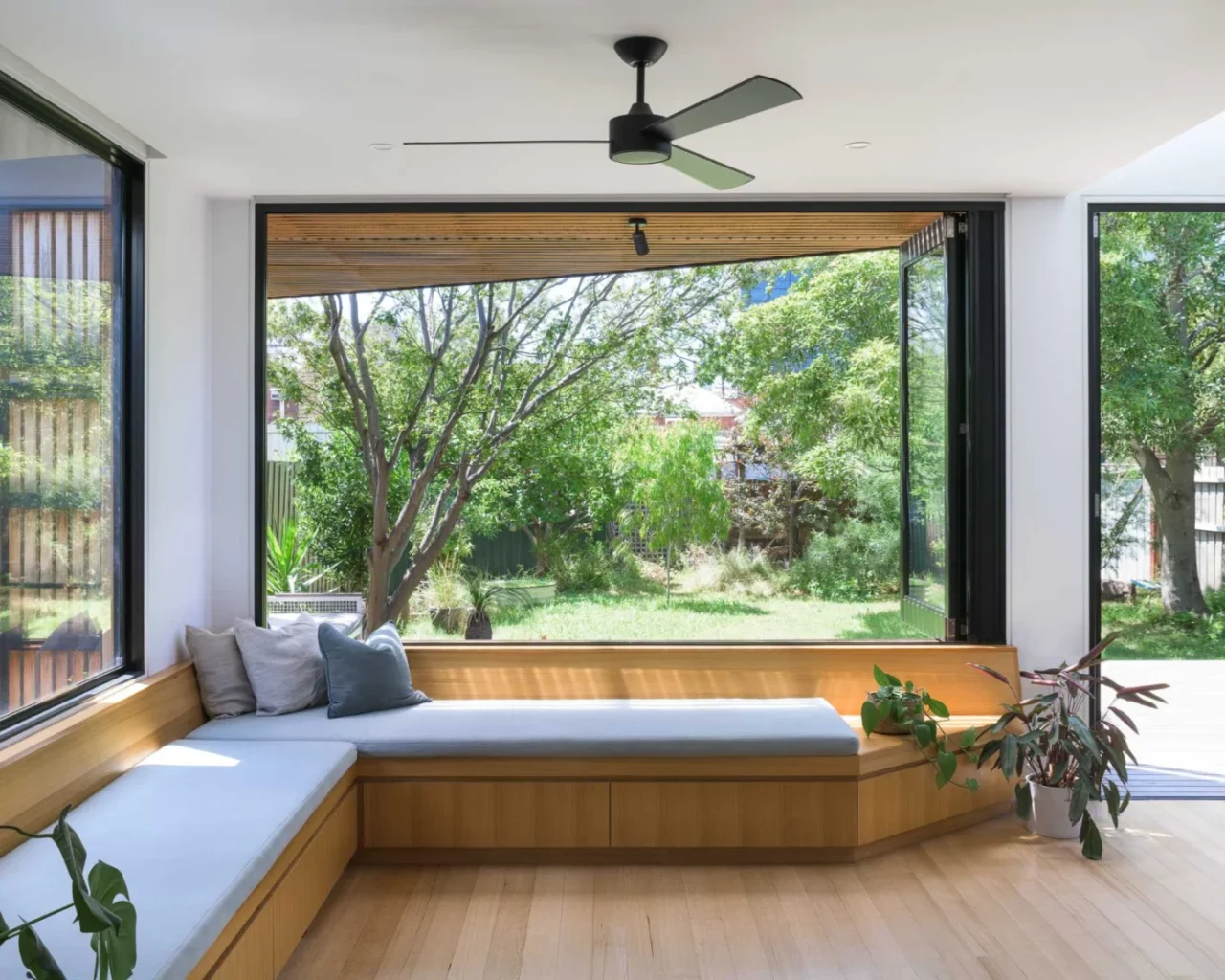 Bench seat beside large bi-fold windows open to the garden