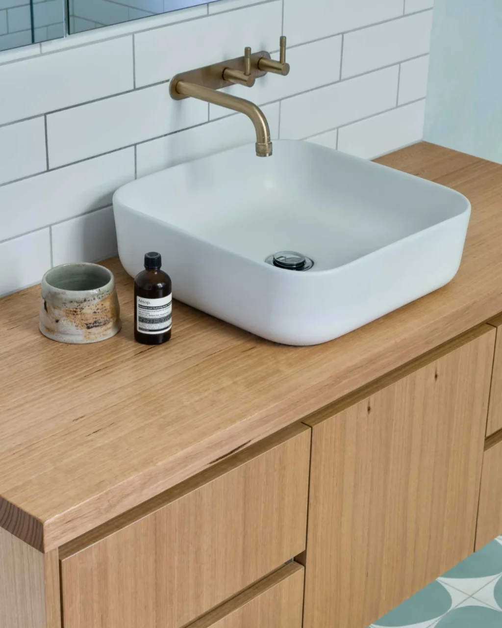 Bathroom with a timber vanity, basin and white subway tiles