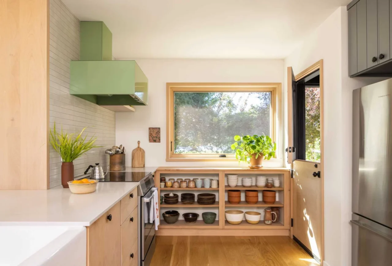 New kitchen with light wood cabinets, open shelving and a pastel green range hood