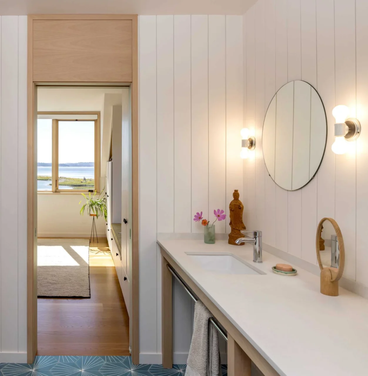 Ensuite bathroom with a wood vanity and round mirror