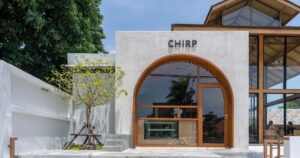 the-large-arch-window-in-front-of-this-cafe-offers-a-glimpse-of-the-creative-interior