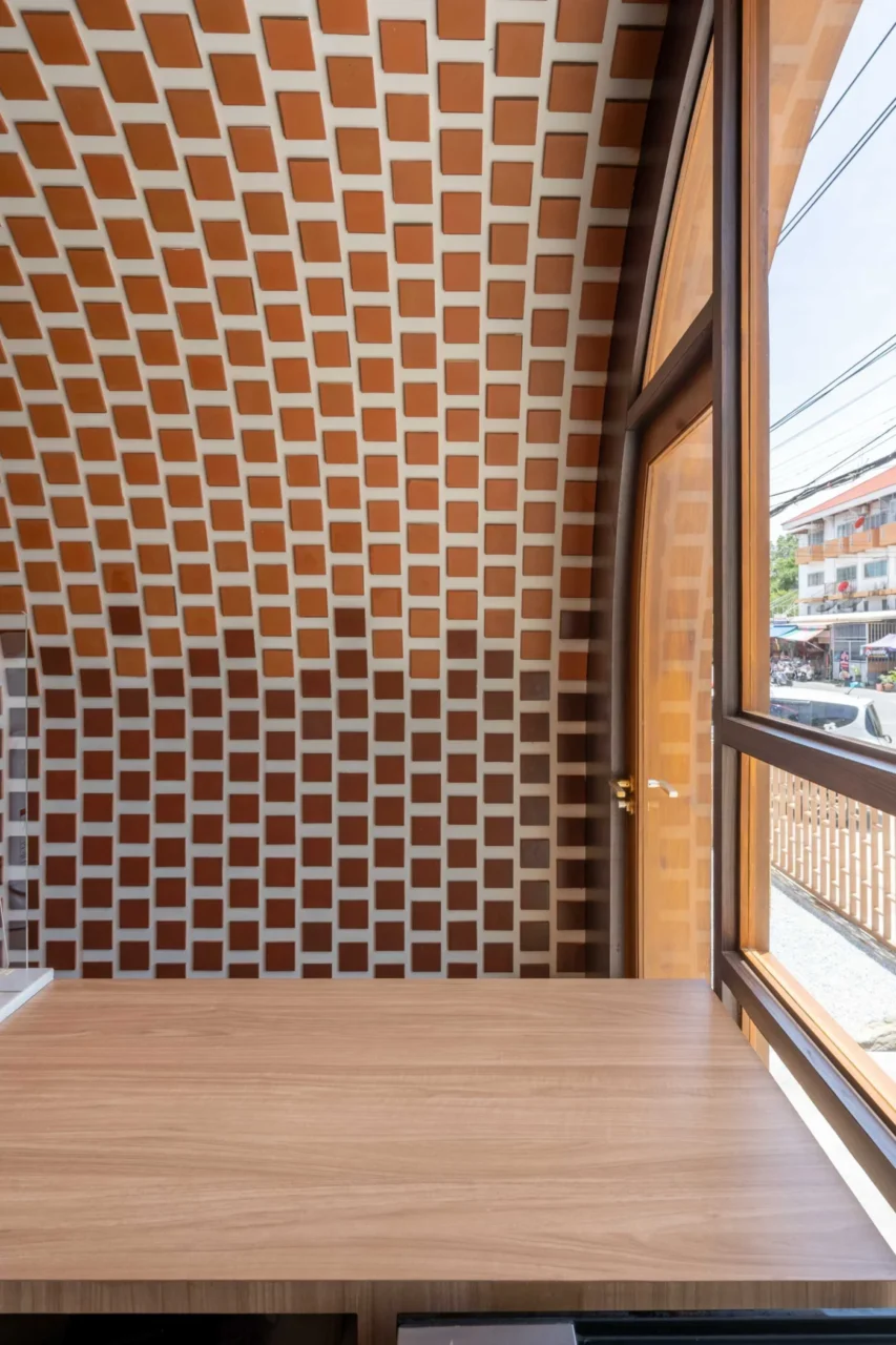 Wall of clay tiles in a gradient from dark brown to light brown