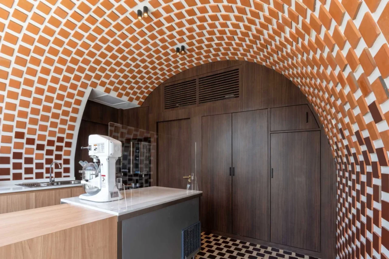 Clay tiles that protrude, casting shadows on the cafe wall