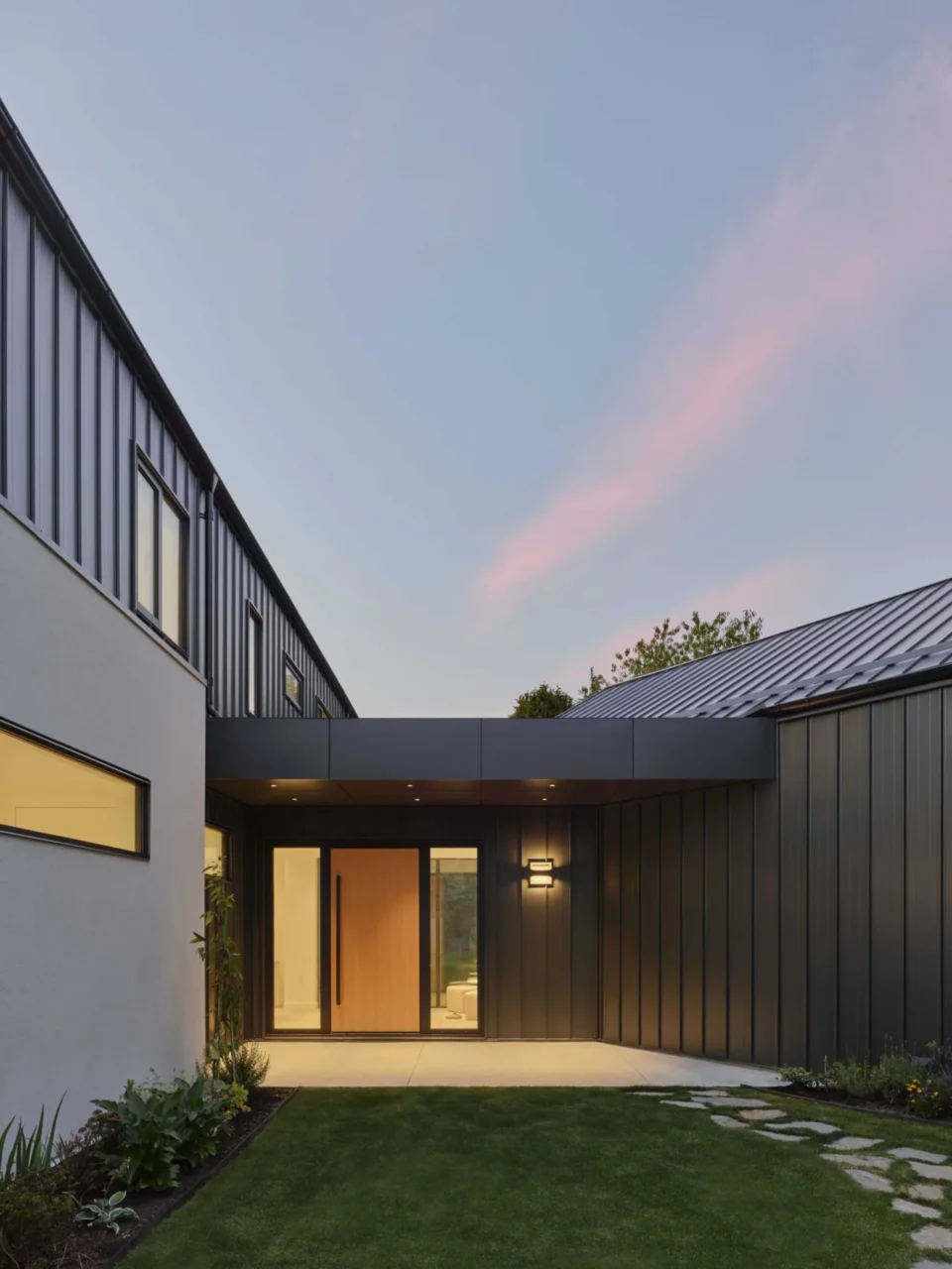Front door opening into the glazed hallway with views of the yard