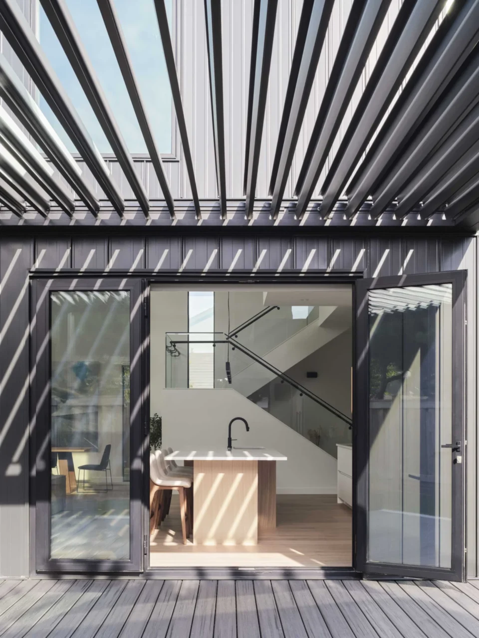 Sliding door from the kitchen to a covered patio with outdoor dining and lounge
