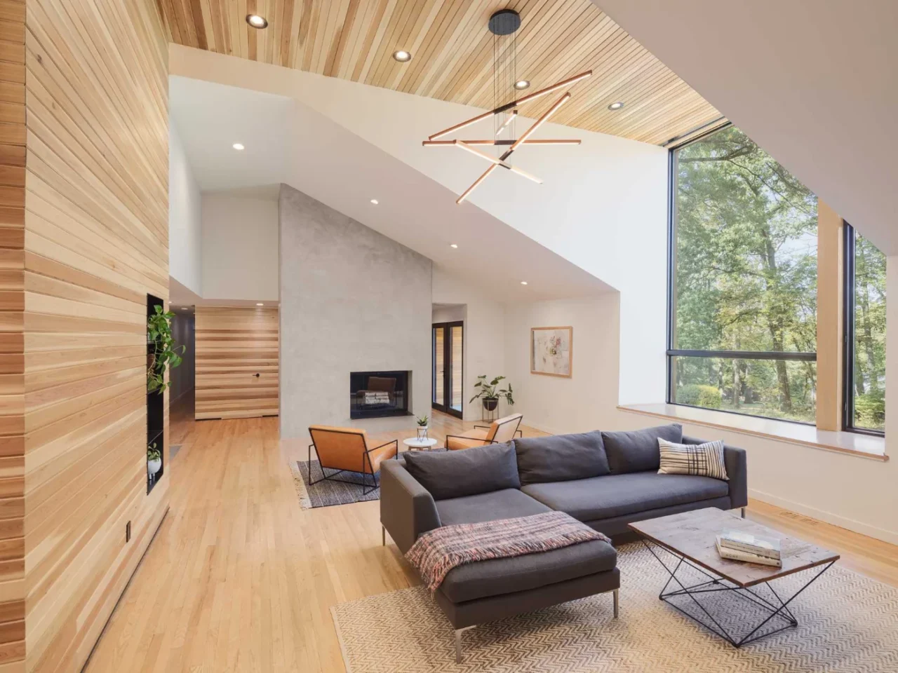 Vaulted living room with a cedar-clad wall and steel-lined pass-through shelving