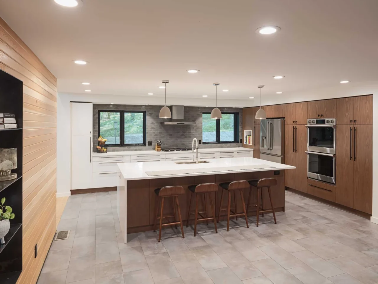 New kitchen with walnut tall cabinets, matte white base cabinets and a large island