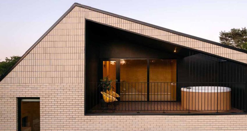 a-sheltered-space-beneath-the-sloping-roof-of-this-home-makes-space-for-a-hot-tub