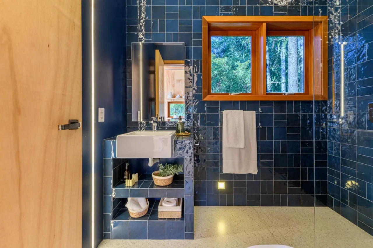 Bathroom with walls and vanity covered in blue tiles