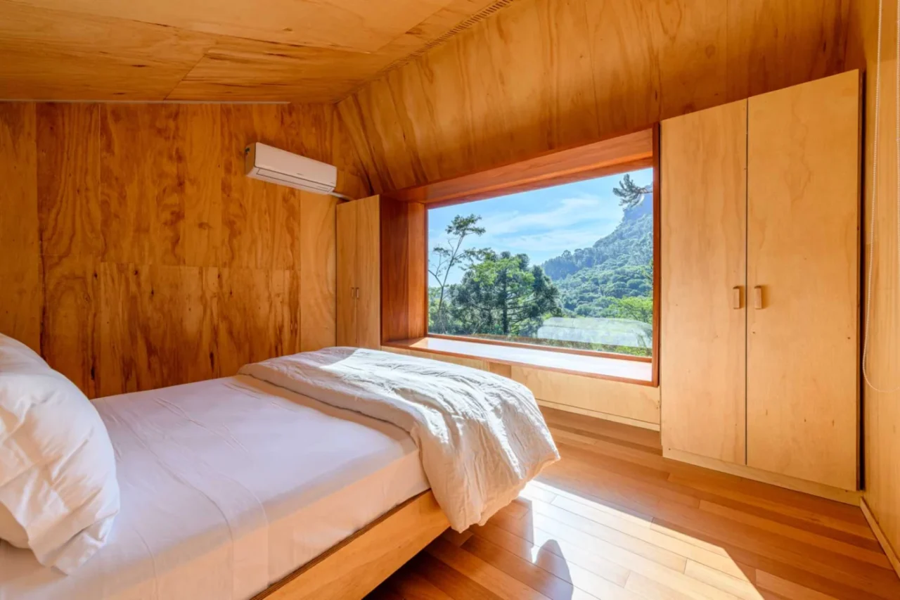 Mezzanine bedroom with two closets around a large picture window and bench