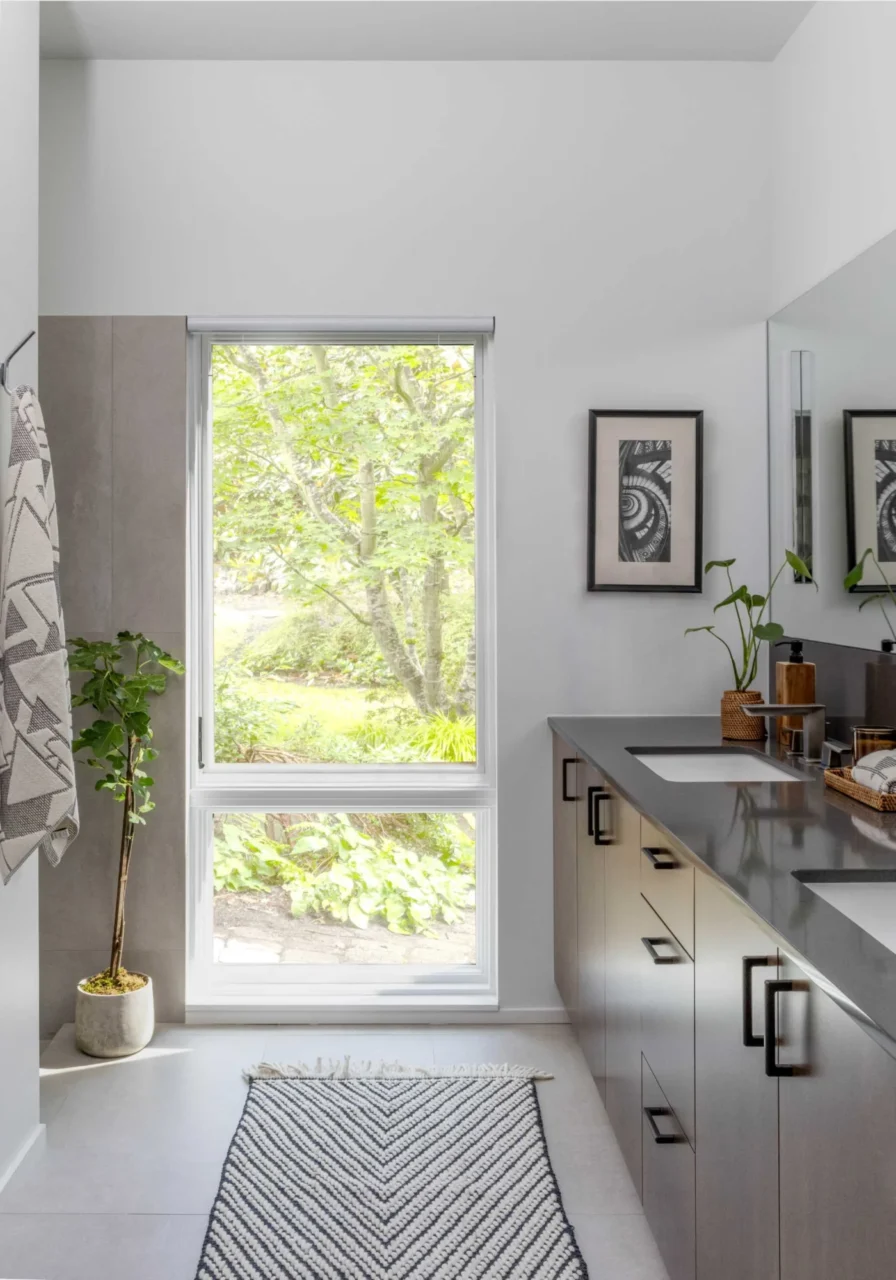 Primary bathroom with a double vanity and tall window