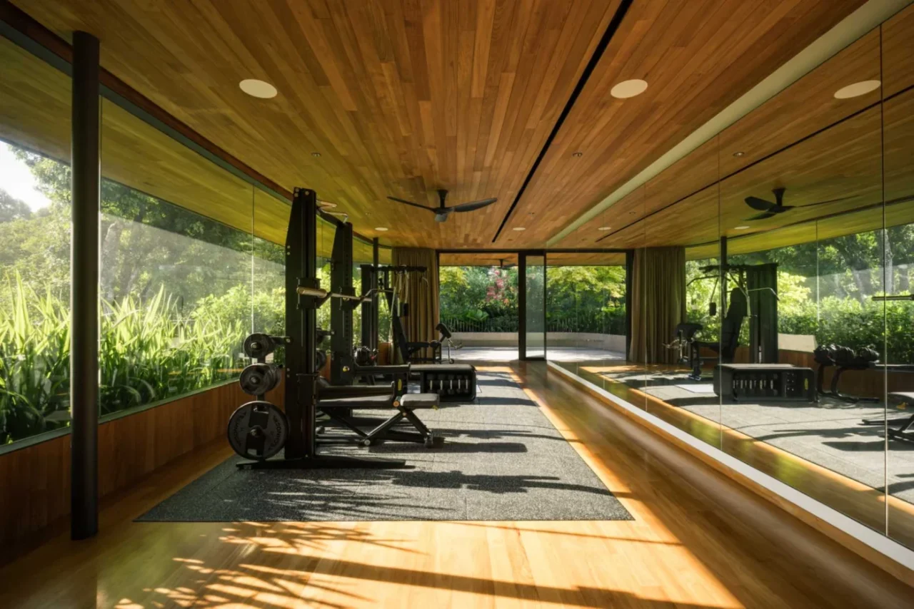 Home gym with a mirrored wall reflecting light and plants