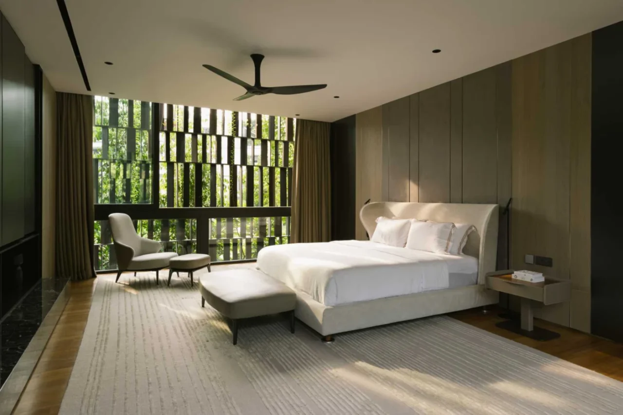 Bedroom in a neutral palette with greenery outside the window