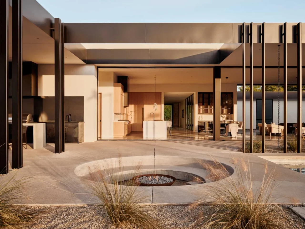 Circular sunken fire pit between the pool and the covered patio