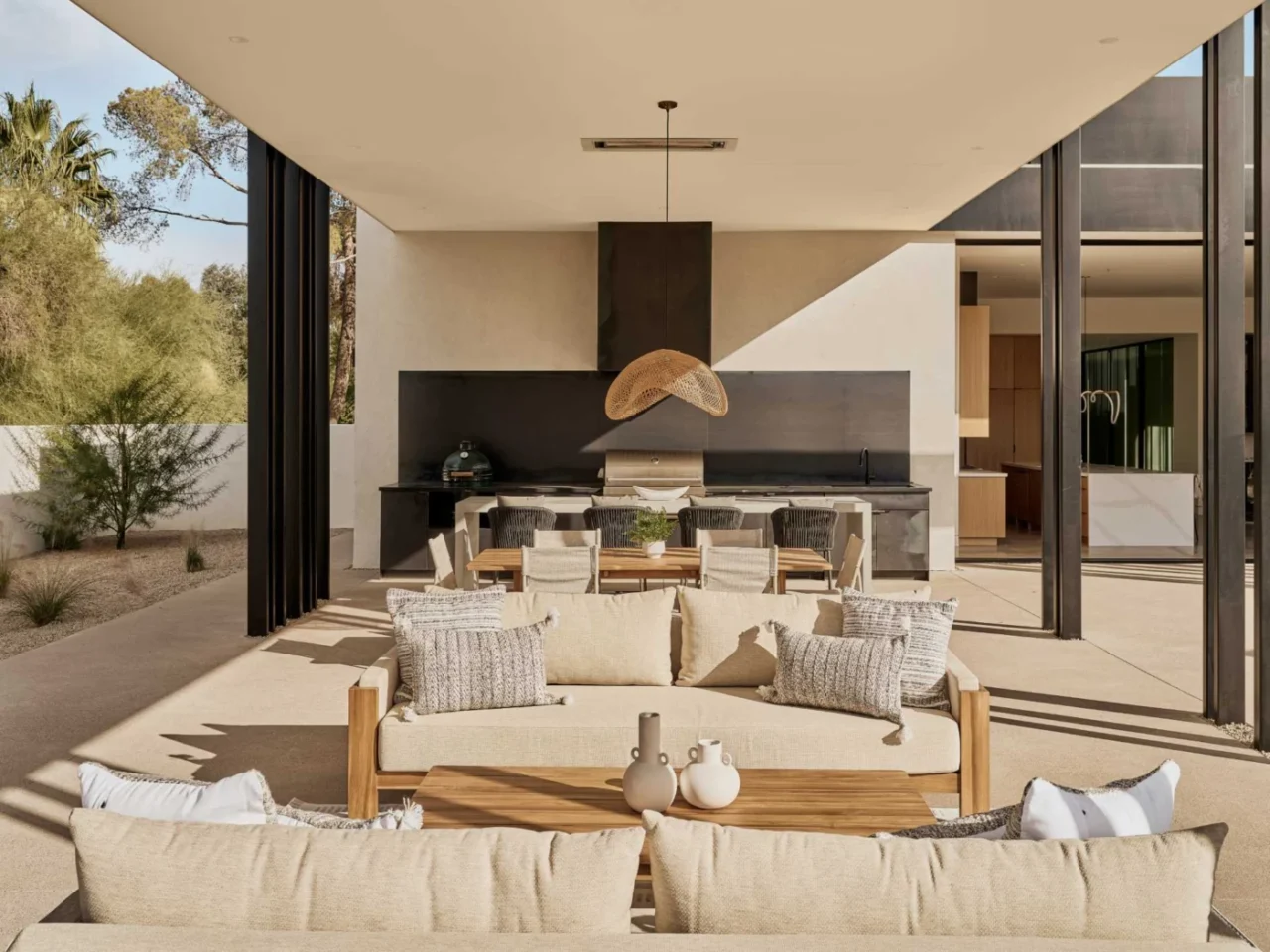 Covered patio with an outdoor kitchen, concrete island and steel fireplace