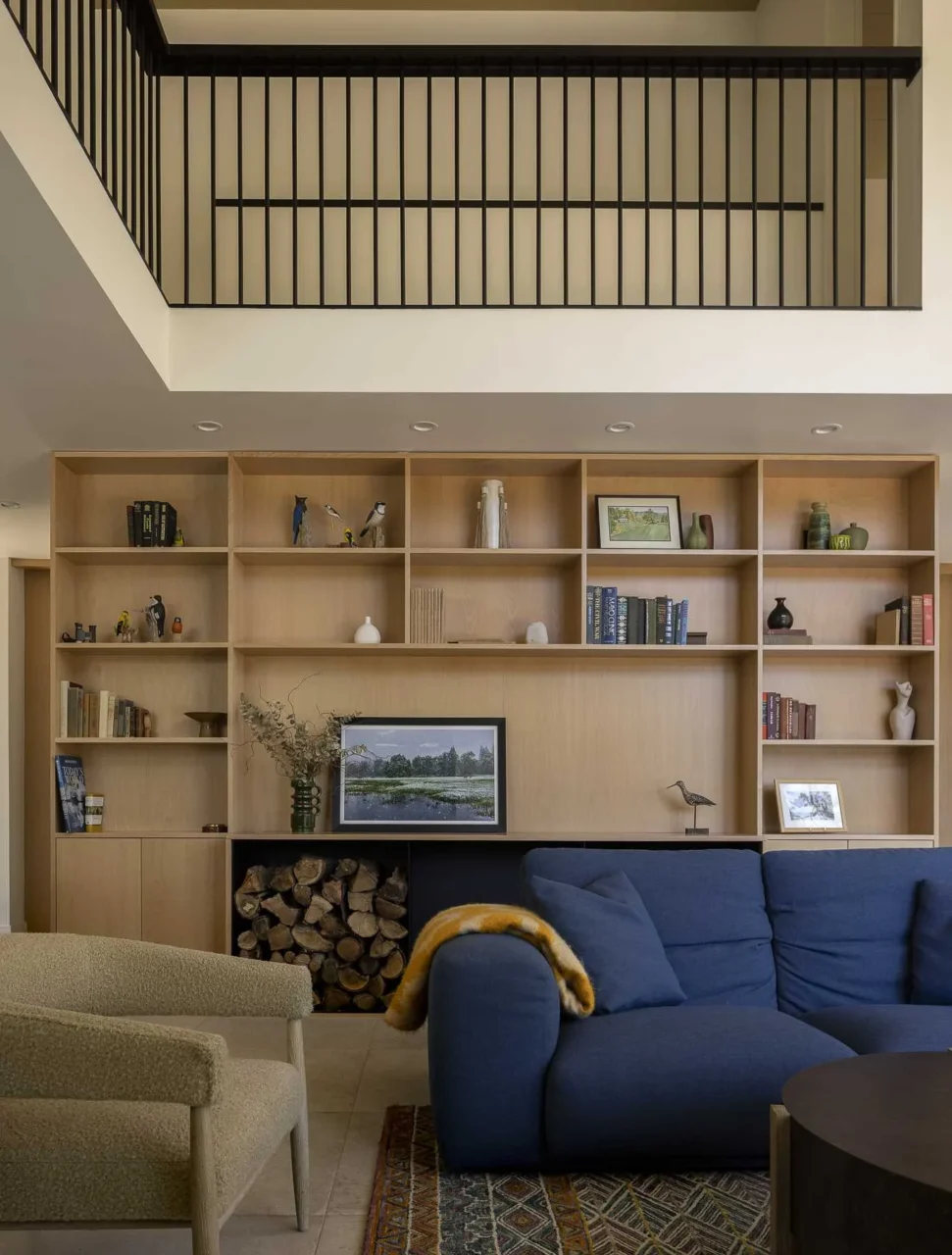 Custom built-in wood shelving behind the sofa for books and decor