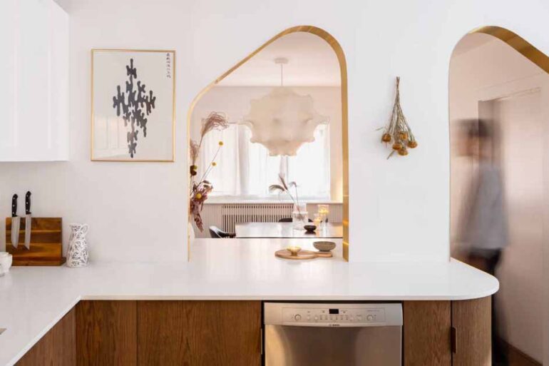 brass-lined-arches-connect-the-kitchen-with-the-dining-room-inside-this-home